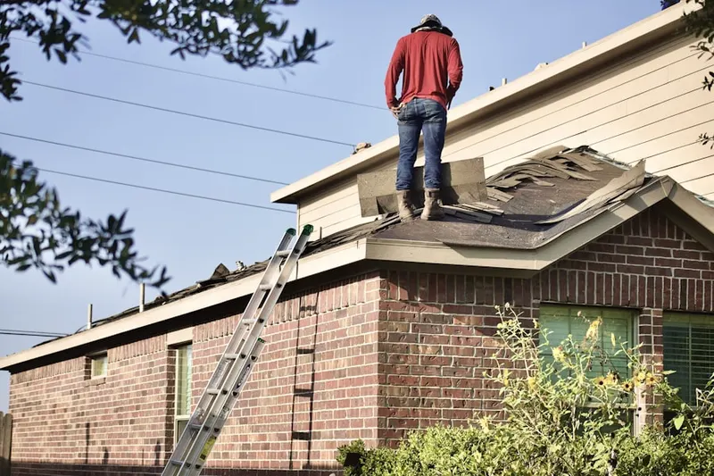 Professional roofer working on a residential roof in Racing Beach